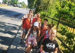 Grupa uczniów spaceruje chodnikiem