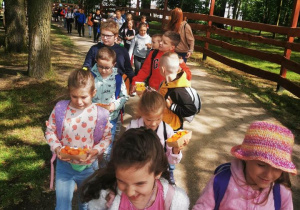 Uczniowie niosą dla zwierząt pokrojona marchewkę