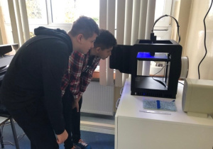 Uczniowie koła informatycznego CMI obserwują jak drukuje drukarka 3D