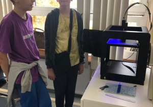 Uczniowie koła informatycznego CMI obserwują jak drukuje drukarka 3D