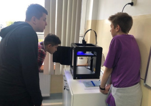 Uczniowie koła informatycznego CMI obserwują jak drukuje drukarka 3D
