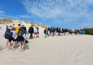 Uczniowie wycieczki spacerują po plaży