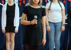 Na zdjęciu uczennica śpiewa piosenkę.