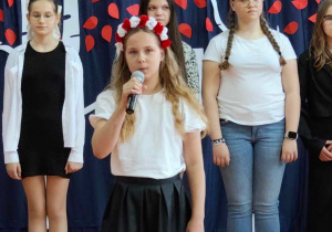 Na zdjęciu uczennica śpiewa piosenkę.