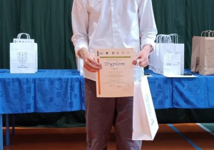 Na zdjęciu nagrodzony uczeń z dyplomem.