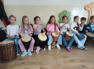 Na zdjęciu uczniowie grają na bębnach.