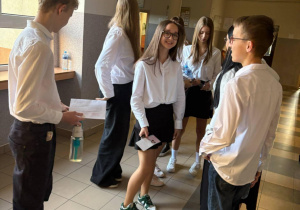 Na zdjęciu uczniowie klas ósmych czekają na korytarzu na egzamin.