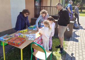 Uczennice grają w gry logiczne podcza festynu.