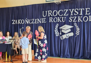 Pani dyrektor wręcza świadectwo uczniowi.