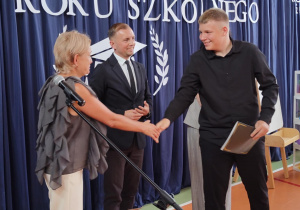 Wychowawca wręcza świadectwo uczniowi.