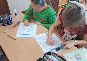 Uczennice wykonują prace plastyczne z okazji dnia kropki