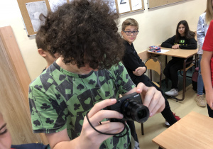 Uczeń z nowoczesnym aparatem fotograficznym