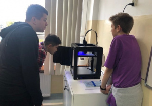 Uczniowie koła informatycznego CMI obserwują jak drukuje drukarka 3D