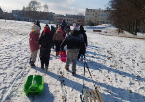 Uczniowie ciągną sanki