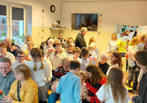 Uczniowie wręczają babciom i dziadkom prezenty