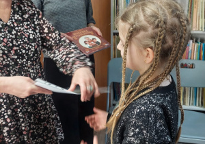 Nauczyciel wręcza uczennicy dyplom