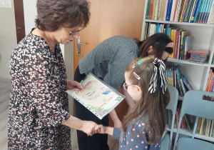Nauczyciel wręcza uczennicy dyplom