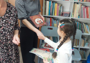 Nauczyciel wręcza uczennicy dyplom