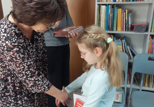 Nauczyciel wręcza uczennicy dyplom