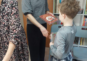 Nauczyciel wręcza uczennicy dyplom