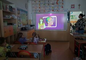 Uczniowie oglądają film o działaniu mózgu.