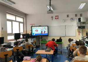 Uczniowie oglądają film o działaniu mózgu.