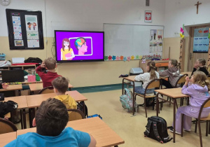 Uczniowie oglądają film o działaniu mózgu.