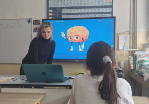 Uczniowie oglądają film o działaniu mózgu.