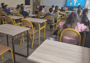 Uczniowie oglądają film o działaniu mózgu.