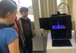 Uczniowie obserwują jak drukuje drukarka 3D