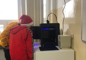 Uczniowie obserwują jak drukuje drukarka 3D