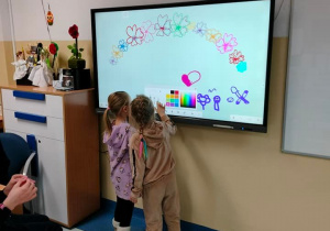 Dziewczynki rysują po tablicy interaktywnej