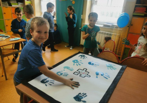 Uczeń robiący dłonią niebieski stempel